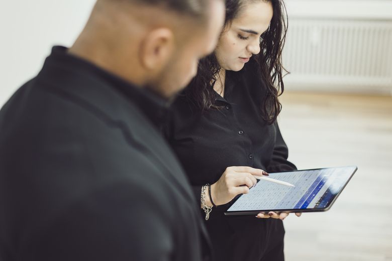 Philip Nolte und Donarta Nura besprechen Zahlen am Tablet